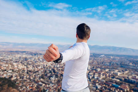 A young strong fit masculine man working out in the morning while looking at the city.の写真素材