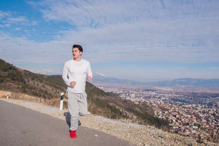 Fit man running down on an empty street on a sunny day.の写真素材
