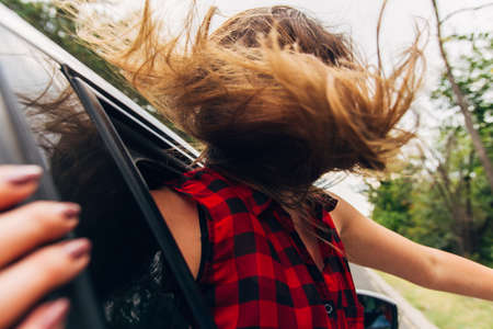 A woman is looking serios while  is driving in some region with small stones