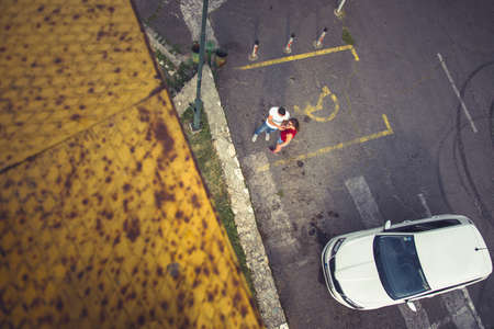 Seeing from above two people who are lightening a cigarette from a high metal boardの写真素材