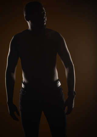 Silhouette portrait of black male posing while being toplessの写真素材