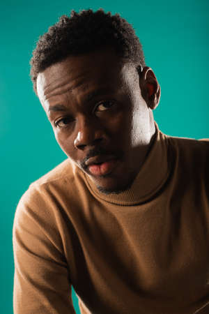 Portrait of young and handsome black male psoing on blue background