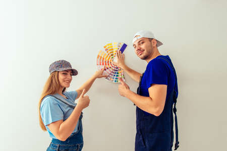 Male and female in overalls choosing true color for the walls