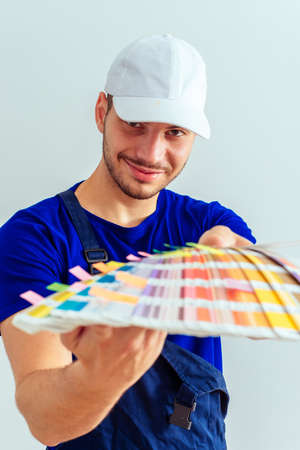 Painter holding color palette in front of the wallの写真素材