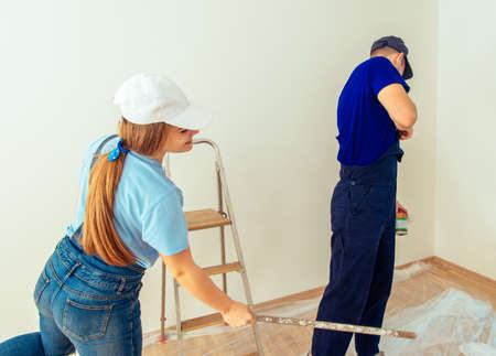 Young married couple in his new apartment prepare to painting wallsの写真素材