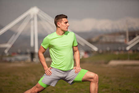 Handsome guy is streching and warming up for his trainingの写真素材