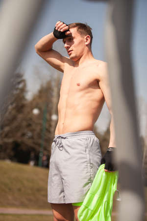 Handsome and attractive male sportsman is taking a break shirtless