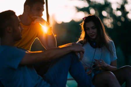 Friends chatting on a benchの写真素材