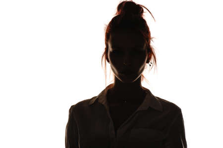 Portrait of an attractive trendy girl in white shirt posing against white wallの写真素材