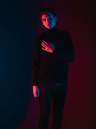 Portrait of a young attractive man dressed in stylish clothing posing isolated on dual tone backgroundの写真素材