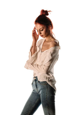 Studio fashion portrait of a modern girl wearing blue jeans and white cropped shirtの写真素材