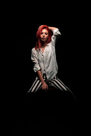 Portrait of an attractive stylish woman posing against black background