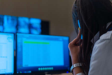 Female security guards working on computers while sitting in the main control room