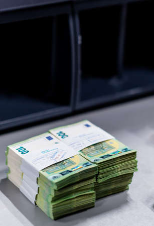 Bundles of euro â‚¬ banknotes divided into groups with currency straps placed on the counting...