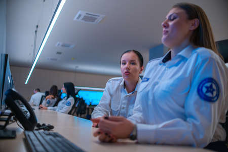 Close up photo of a security female agent monitoring the CCTV in a main data center office.の写真素材