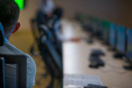 Security guard monitoring modern CCTV cameras in a surveillance room.の写真素材