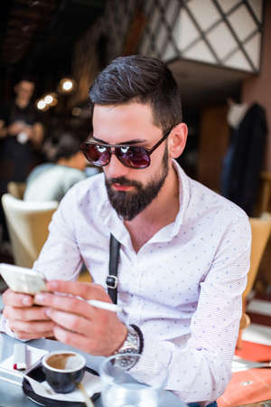 Handsome young man spending his free time at the cafe bar in the afternoon
