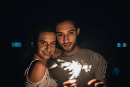 Young couple sharing happy and love mood on the mountain with pyrotechnicsの写真素材
