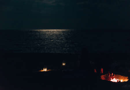 Young people celebrating during summer vacation, near fireplace by nightの写真素材