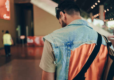 Man waiting for his flight on background blur airport check-In counters and passenger