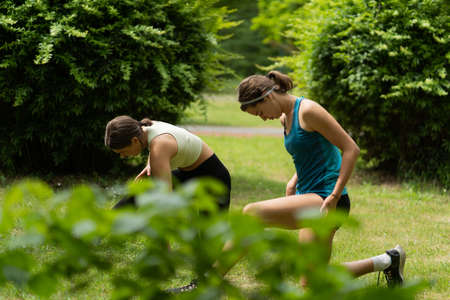 Two attractive and beautiful girls are warming up so they can do some yoga stretches