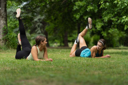 Two attractive girls doing some yoga while the one girl is teaching the other