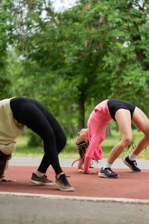 Two attractive and beautiful young girls are bending their back abnormally