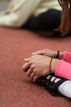 Close up portrait of her shoes while they both are stretching before the trainngの写真素材