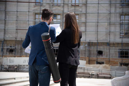 Two business partners are discussing about the plan for the buildings