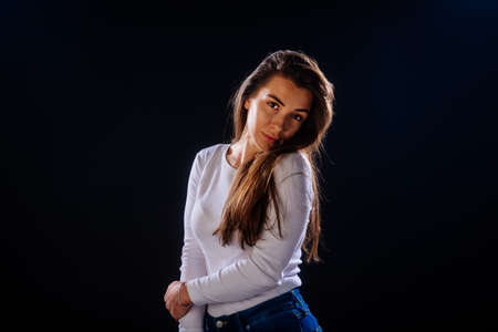 Portrait of an attractive girl holing her hair, while looking handsome and satisfied.
