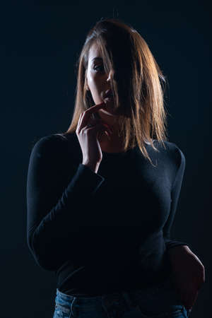 Silhouette picture of beautiful woman posing on black backgroundの写真素材