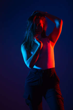 Female model posing in studio with red and blue colors at high contrast.の写真素材