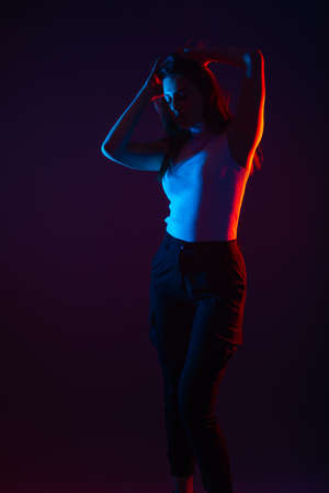 Blue and red light portrait of a female model on a black background with high contrastの写真素材