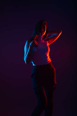 Blue and red light portrait of a female model on a black background with high contrastの写真素材