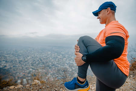 Fit mature man dressed in sportswear working out outdoorsの写真素材