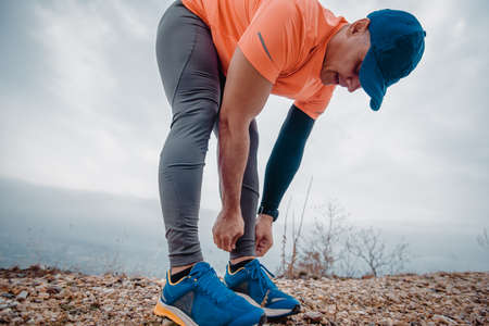 Muscular man wearing sport clothes during preparation for running exerciseの写真素材