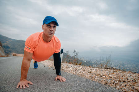 Well built man over 40 wearing activewear training push up getting ready for a run