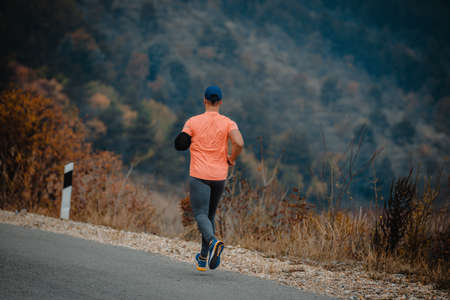 Mature man over 40 wearing sport clothes during a jogging exerciseの写真素材