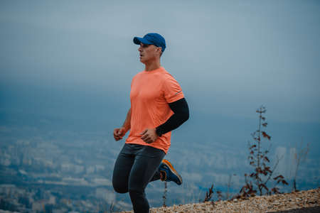 Fit mature man dressed in sportswear working out outdoorsの写真素材