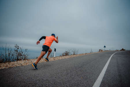 Athletic older man in sport clothes sprinting outdoorsの写真素材
