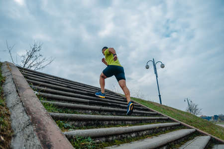 Fit mature man dressed in sportswear working out outdoorsの写真素材