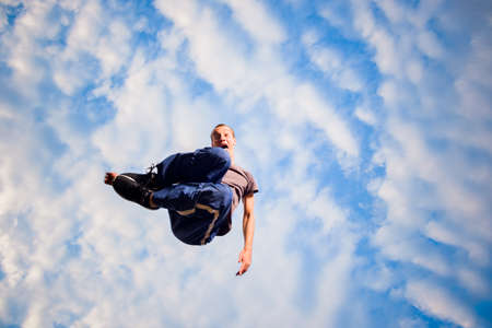 Parkour man below blue sky doing parkour tricks