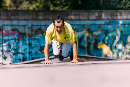 Training day of a young parkour man jumping over obstacles in skateparkの写真素材