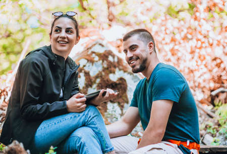 Young couple in the forest, summer nature, bright sunlight, shadows and green leaves, romantic feelingsの写真素材