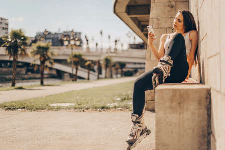 Beautiful girl with roller skates is taking selfiesの写真素材