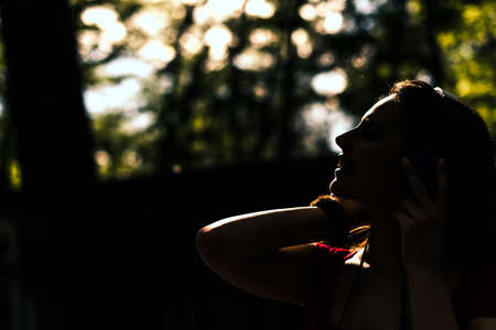 Young silhouette woman in headphones is listening to music