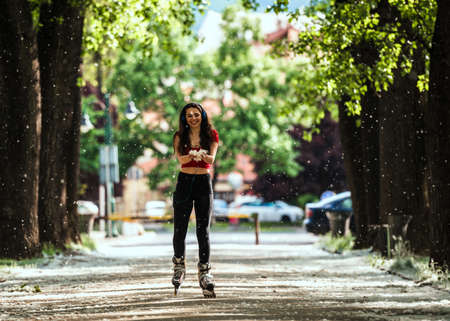 Brunette girl with headphones in the park listening music on headphonesの写真素材