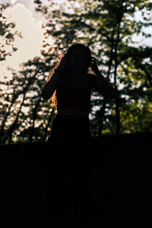 Happy young fit woman using cell phone while listening to music on smartphoneの写真素材