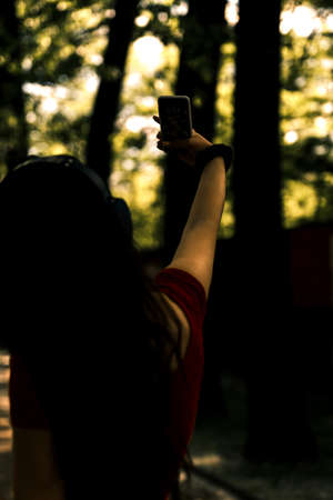 Cute girl rollerblading outdoors using her smart phone for selfieの写真素材