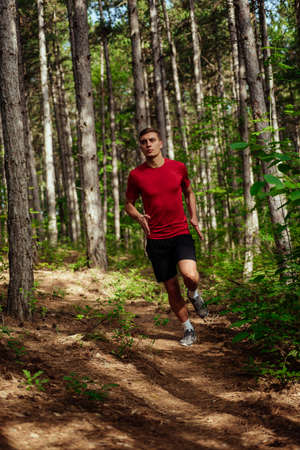 Fitness male sport fitness model sprinting outdoors on mountain pathの写真素材